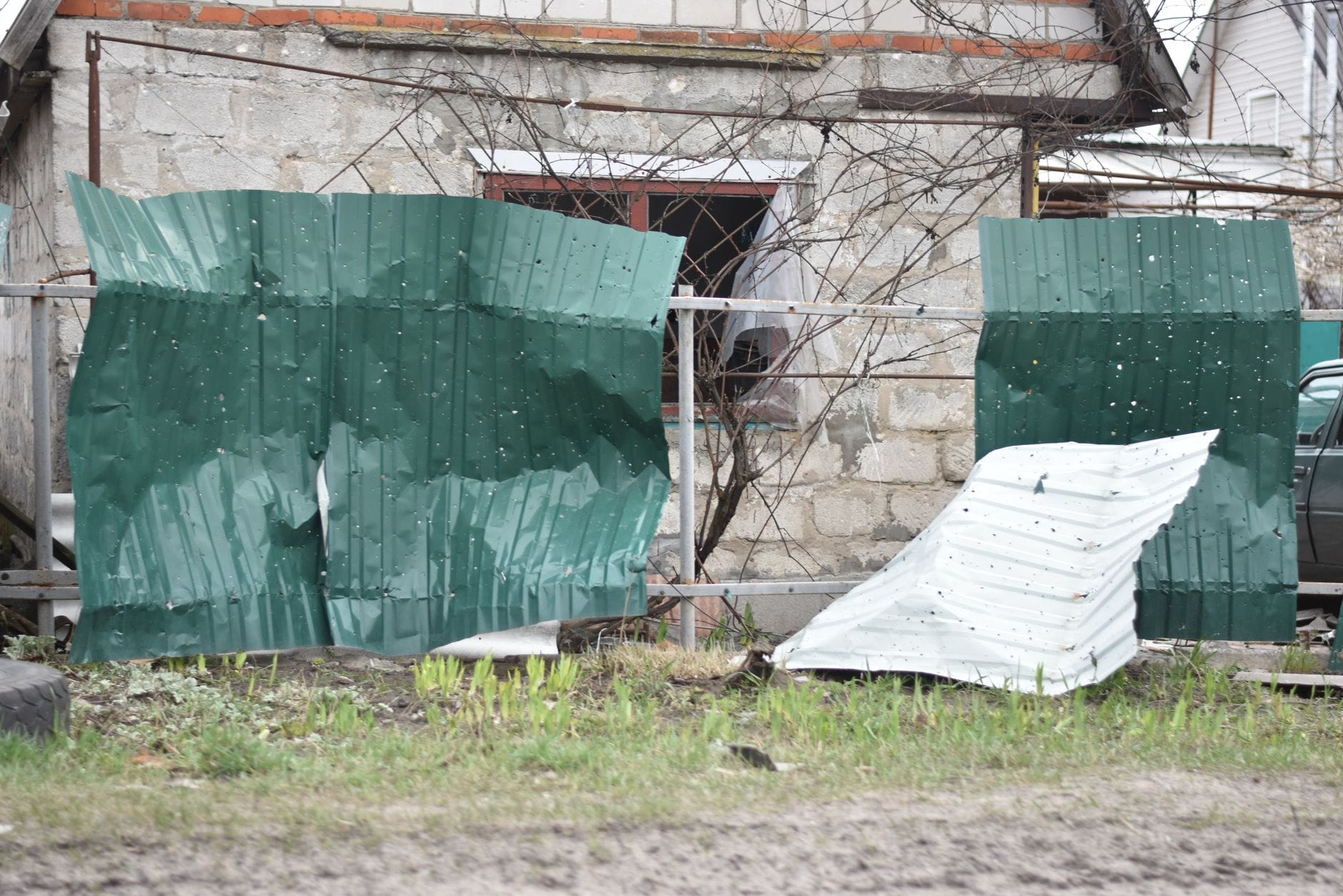 Zardzewiałe metalowe ogrodzenie przy starym, zaniedbanym domu Zardzewiałe metalowe ogrodzenie przy starym, zaniedbanym domu