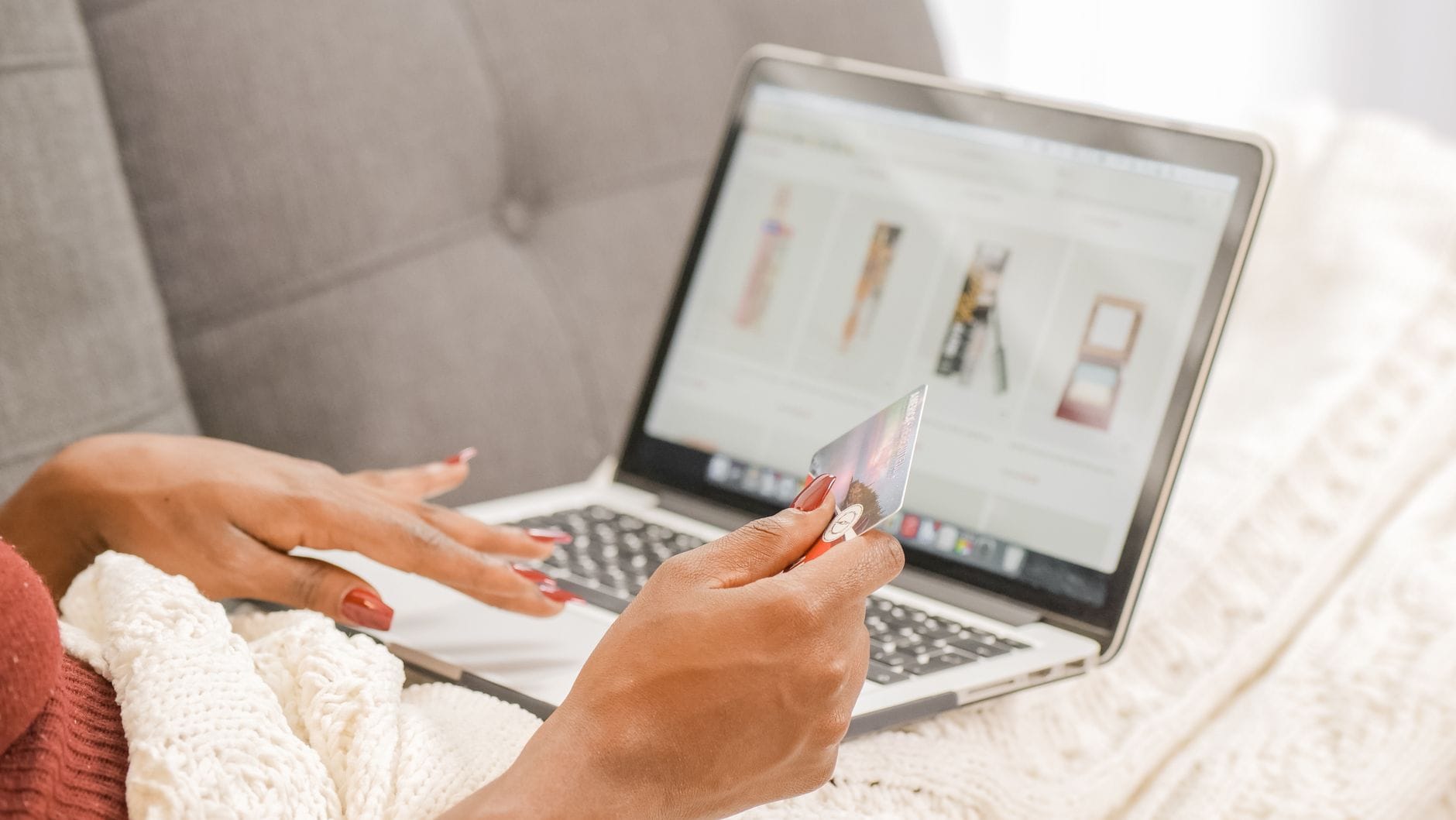 Kobieta na kanapie robi bezpieczne zakupy online na laptopie z kartą