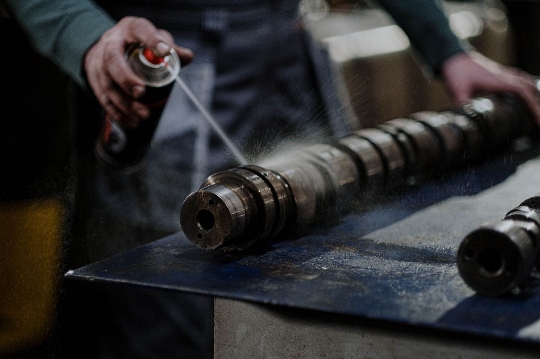 Mechanik spryskuje odtłuszczaczem metalowy wałek rozrządu silnika